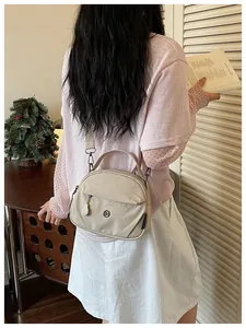 Bolso bandolera de nailon beige informal para mujer visto desde atrás en un modelo real