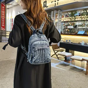 Fashionable blue denim mini backpack for women shown in a lifestyle cafe setting