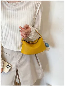 Close-up detail of a bright yellow pebbled leather handbag with a unique turn-lock closure