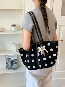 Stylish black and white polka dot tote bag for women with a decorative palm tree charm