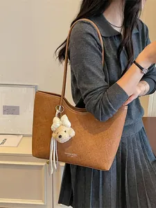 Large capacity tan tote bag with plush bear charm and textured finish for women