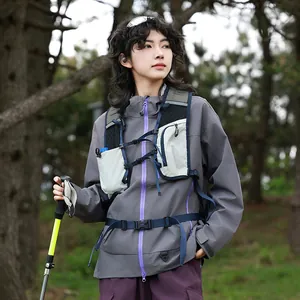 Ein Outdoor-Modell trägt eine professionelle Wanderweste und eine graue Funktionsjacke