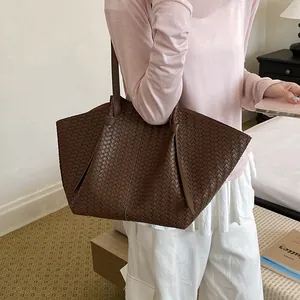 Casual dark brown woven tote bag for women shown in a lifestyle setting
