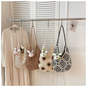 Borse tote all'uncinetto fatte a mano in quattro fantasie appese per le vacanze.