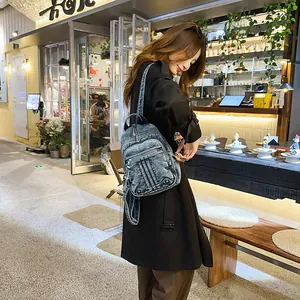Stylish blue denim mini backpack for women shown in a casual urban cafe setting.