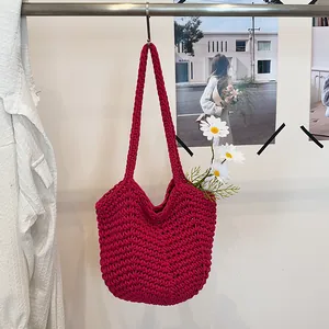 Handmade deep pink crochet shoulder bag featuring intricate knit texture and floral decoration