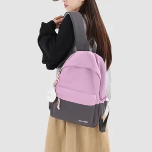 Female student wearing a stylish pink and gray color-block backpack in college style