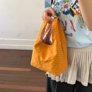 Detailansicht der gelb gestreiften Eimertasche aus Stoff mit rosa Herzmuster-Innenfutter