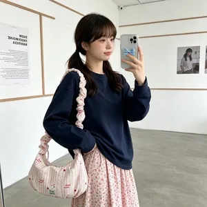 Lifestyle view of pink striped ruffled-strap dumpling bag on an Asian model