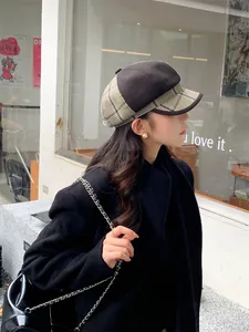 Nahaufnahme einer Frau mit einer Vintage-Karo-Schirmmütze in einer städtischen Straßenszene