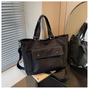 Large capacity black canvas tote bag for travel and daily casual use in lifestyle setting