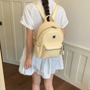 Foto di una modella che indossa uno zaino retrò color crema con trama intrecciata