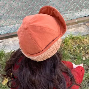 Stylish burnt orange winter trapper hat with warm beige sherpa fleece lining for women