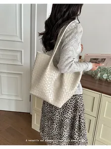 Large beige woven tote bag for women shown in a stylish elegant lifestyle setting