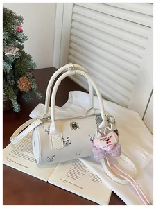Detailed view of the white cylinder handbag featuring colorful cartoon illustrations and charm