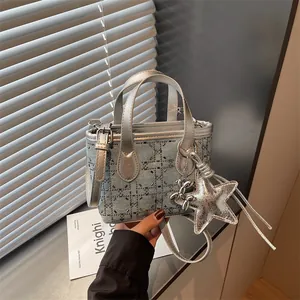 Detailed view of women's denim handbag with rhinestones and star charm decor