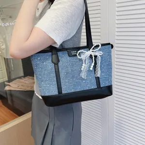 Sac cabas élégant en denim bleu avec garniture noire et détail de nœud en perles et dentelle