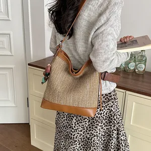 Stylish large capacity straw bucket bag with beads worn by model for daily commute