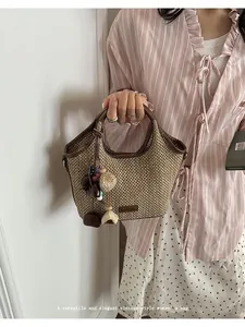 Gros plan d'un sac à main en paille tressée de style français tenu par un mannequin
