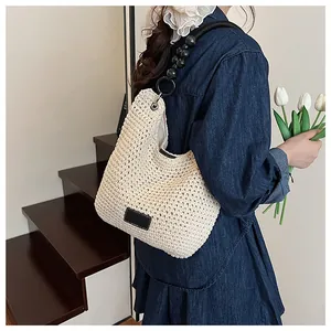 Model wearing a hand-knitted beige bucket bag with a stylish black beaded strap