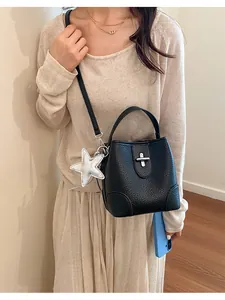 Vue détaillée d'un sac seau chic en cuir grainé noir avec un charm en forme d'étoile