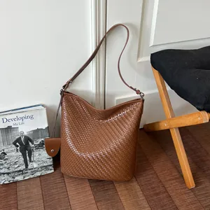 Detail van een retro bruine gevlochten emmertas in een gezellige huiselijke sfeer