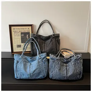 Vue détaillée de trois sacs cabas en jean de différents délavages sur une étagère