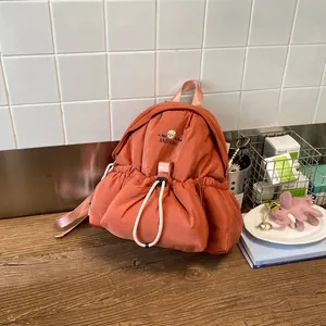 Foto de estilo de vida de una mochila abullonada terracota única en una mesa de madera rústica