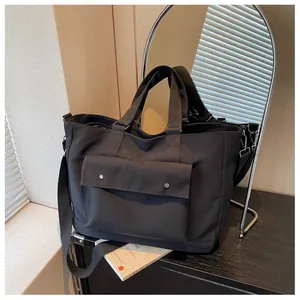 Black large capacity canvas tote bag for travel and daily casual use in a room