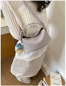 Close-up detail of lavender leather bucket bag with cute bear charm and silver turn-lock
