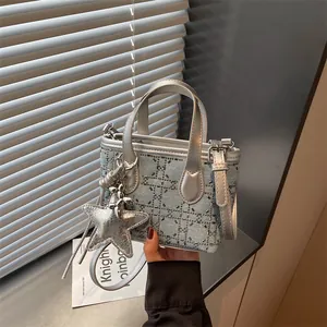 Detail view of denim handbag with silver star charm and beaded pattern decoration
