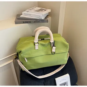 Vue détaillée du sac de voyage extensible vert clair avec de larges poignées.