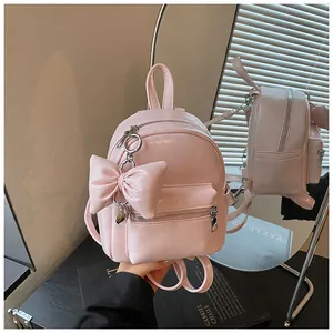 Detailansicht eines trendigen pinkfarbenen Mini-Rucksacks mit großer Schleife und Herz.
