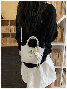 Modèle portant un sac seau bandoulière bleu clair au design de niche en librairie