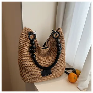 Chic woven bucket bag with beaded handles and a minimalist summer vacation vibe