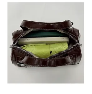 Dettaglio capacità interna della borsa vintage marrone con spazio per telefono e ombrello