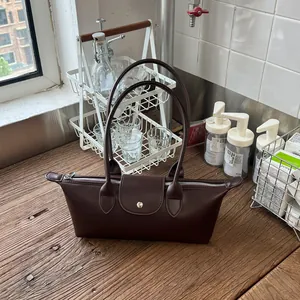 Vue détaillée de côté d'un sac dumpling marron chocolat sur un comptoir en bois
