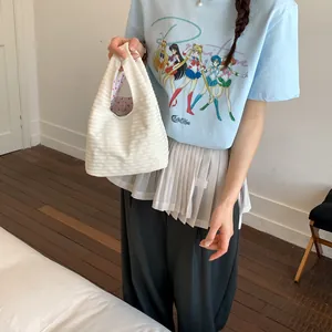 Nahaufnahme einer weiß gestreiften Handtasche in einer lässigen Umgebung