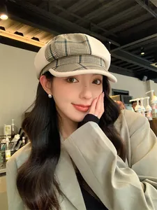 Detailansicht eines asiatischen Models mit einer britischen Retro-Karo-Mütze in einem Café.