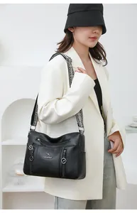 Stylish black pebbled leather crossbody bag with multi-layer zippers and patterned strap