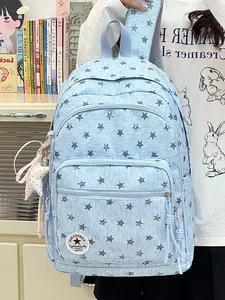 Detailed view of light blue backpack with grey star pattern and circular logo patch