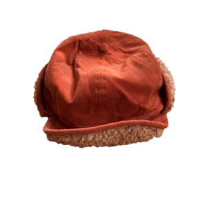 Warm winter sherpa earflap hat in rust orange with soft fleece lining