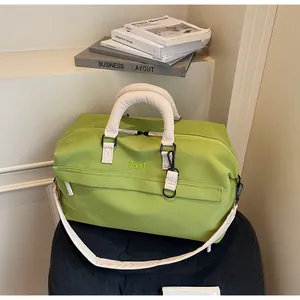 Vue détaillée du sac de voyage vert grande capacité avec poignées blanches et bandoulière