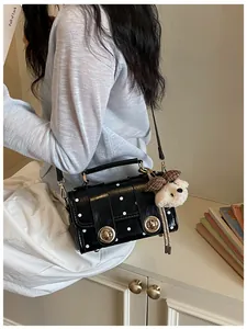 Retro black polka dot crossbody bag for women featuring gold locks and a cute teddy bear charm