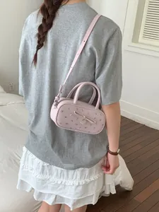 Sweet pink floral bowling bag with bow detail worn as a crossbody bag