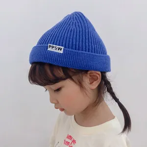 Cute blue children's knitted beanie hat with a white PPSW letter label and cuffed brim