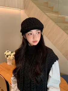 Stylish black knitted newsboy cap for women shown in a cozy retro indoor setting