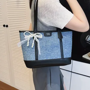 Sac cabas en denim minimaliste avec bordure en cuir noir et nœud en dentelle perle