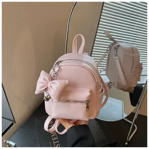 Nahaufnahme eines rosa Mini-Rucksacks mit Schleifenanhänger und Spiegelreflexion