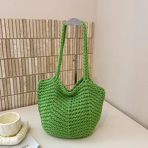 Detailed view of a handmade green knitted shoulder bag with textured crochet pattern